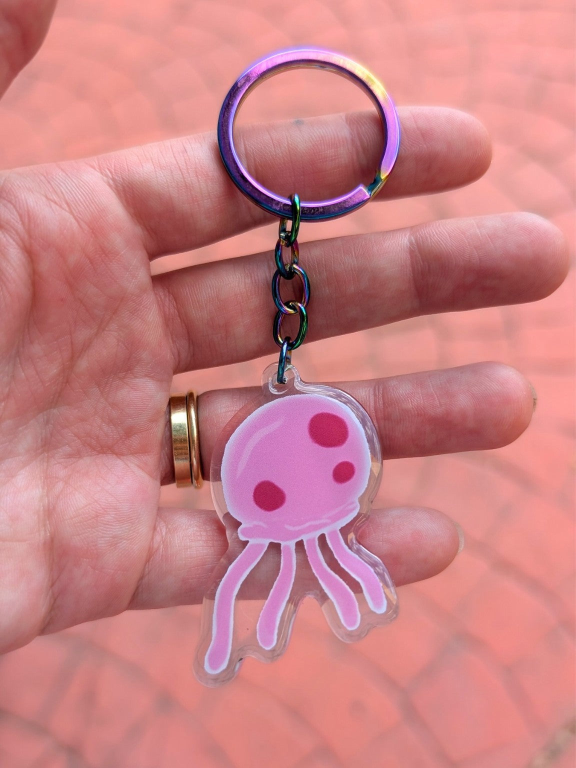 pink jellyfish keychain in hand with iridescent keyring