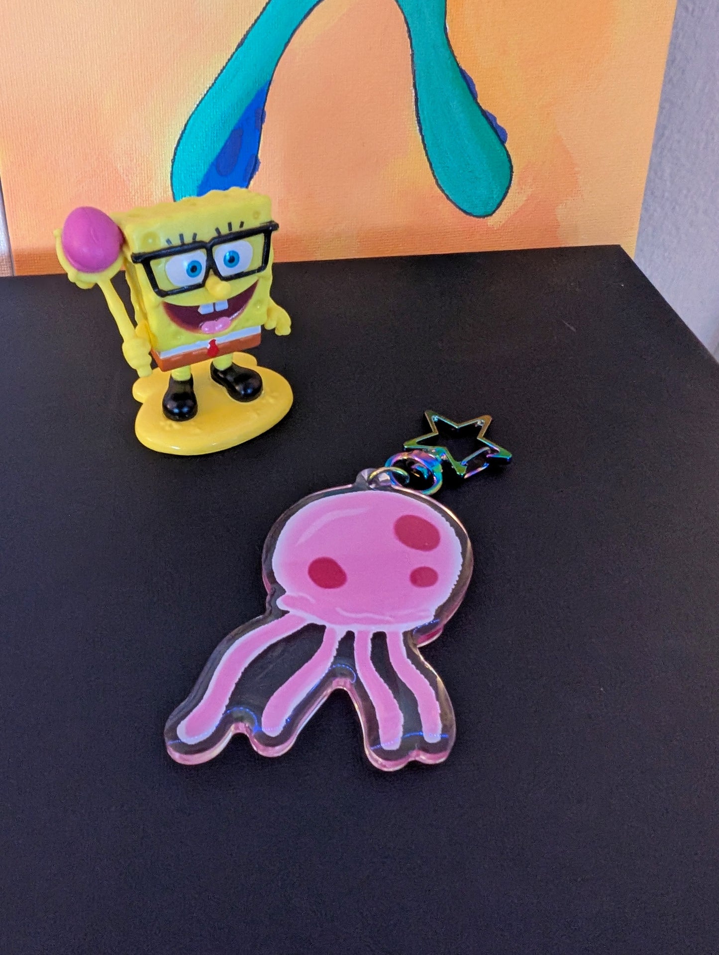 pink jellyfish keychain inspired by the tv show spongebob squarepants. contains a star shaped iredescent keyring