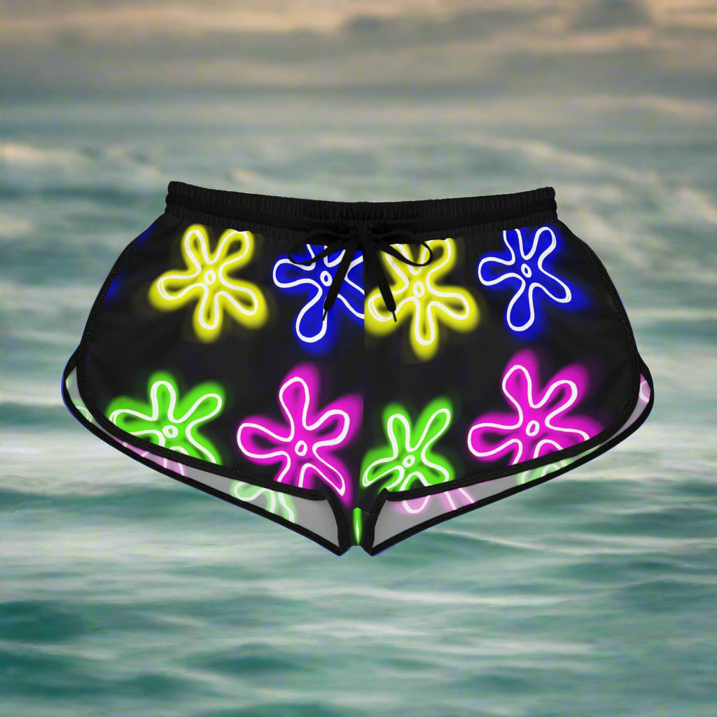 womens running shorts with black material and black drawstrings and trim. has neon flower clouds pattern.