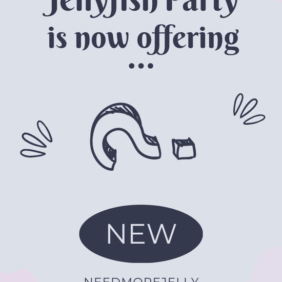 video reveal of JellyfishParty's NEEDMOREJELLY Small-batch Blackberry Jelly on a wooden outdoor display with white paint and a blurred out tree in the background. Blackberries are illustrated on a circle label with purple jelly inside a sealed jar with a golden lid.